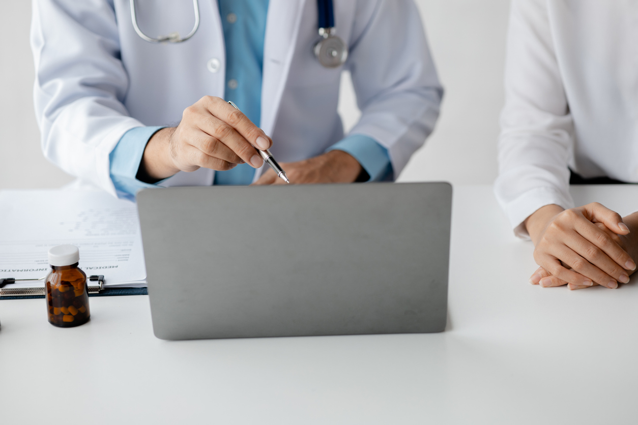 Arzt im Beratungsgespräch mit Patientin am Laptop – Datenschutzbeauftragter Arztpraxis