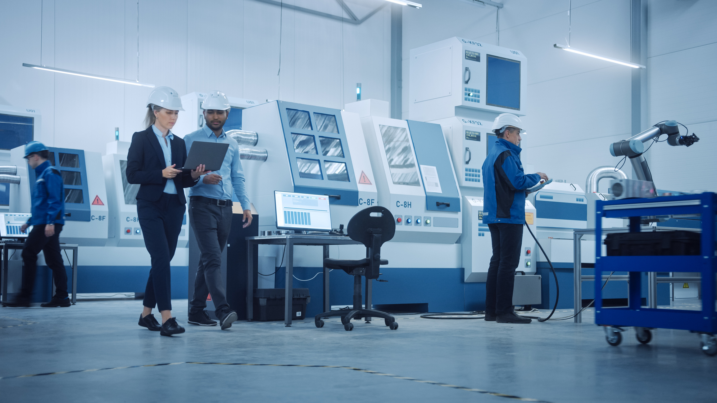 Moderne Fabrik mit professionellen Arbeitern, Ingenieuren, Managern, die an der Produktionslinie arbeiten, Werkstattmanagement, Optimierung. Industrieanlage: Ausgestattet mit CNC-Maschinen und Roboterarmtechnik