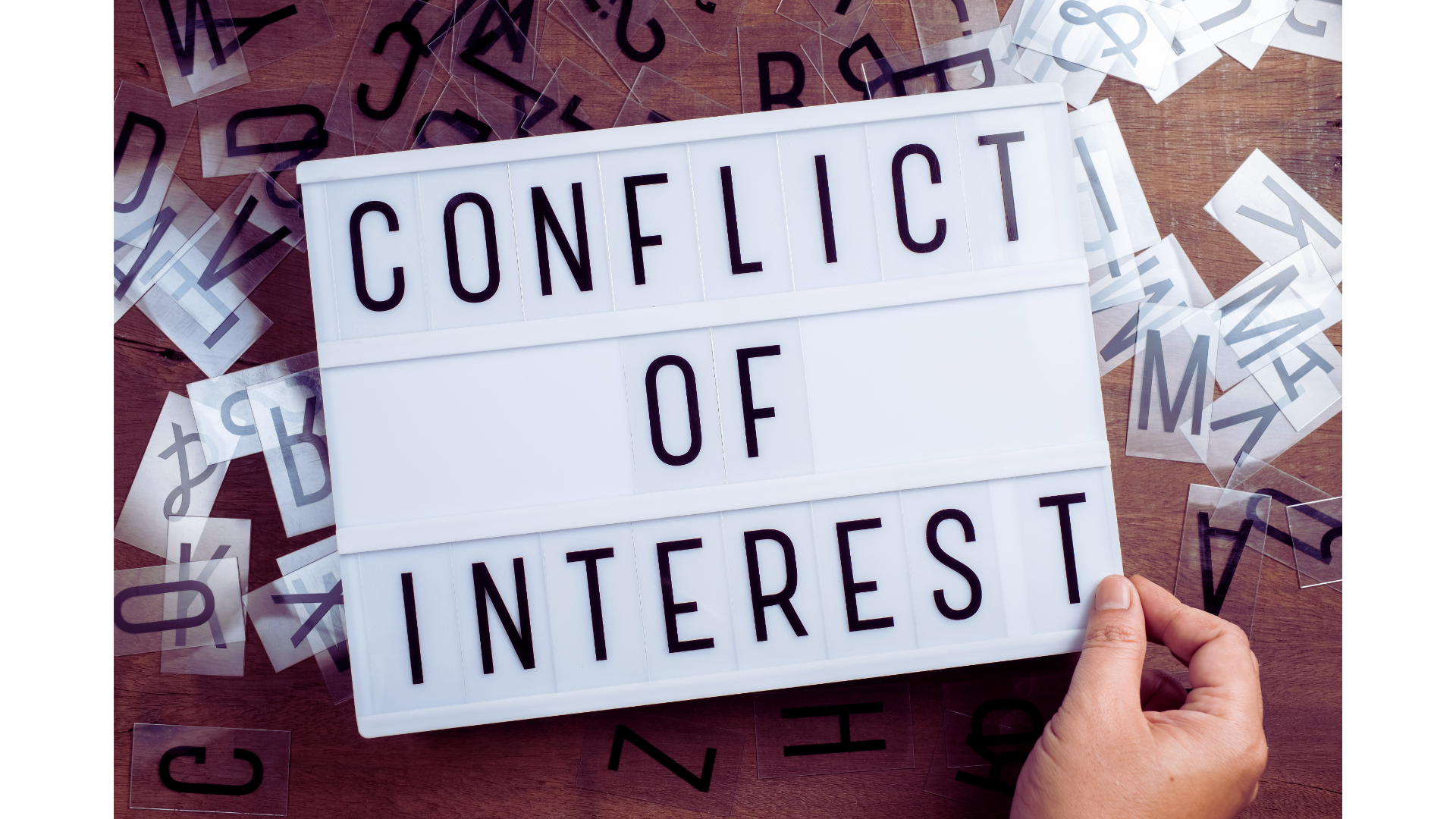 Hand legt Buchstaben in ein Leuchtfeld mit dem Text „Conflict of Interest“ – Symbolbild für Interessenskonflikt und fehlende Aufgabentrennung in der Informationssicherheit
